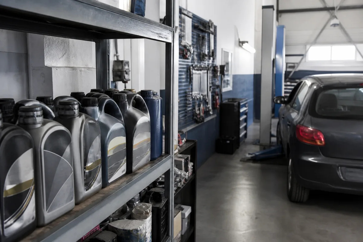Bidons d&rsquo;huile moteur alignés sur une étagère d&rsquo;atelier avec étiquettes visibles